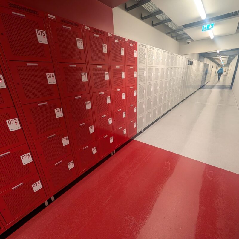 Punased ja hallid riietuskapid elektrooniliste lukkudega spordihoone koridoris